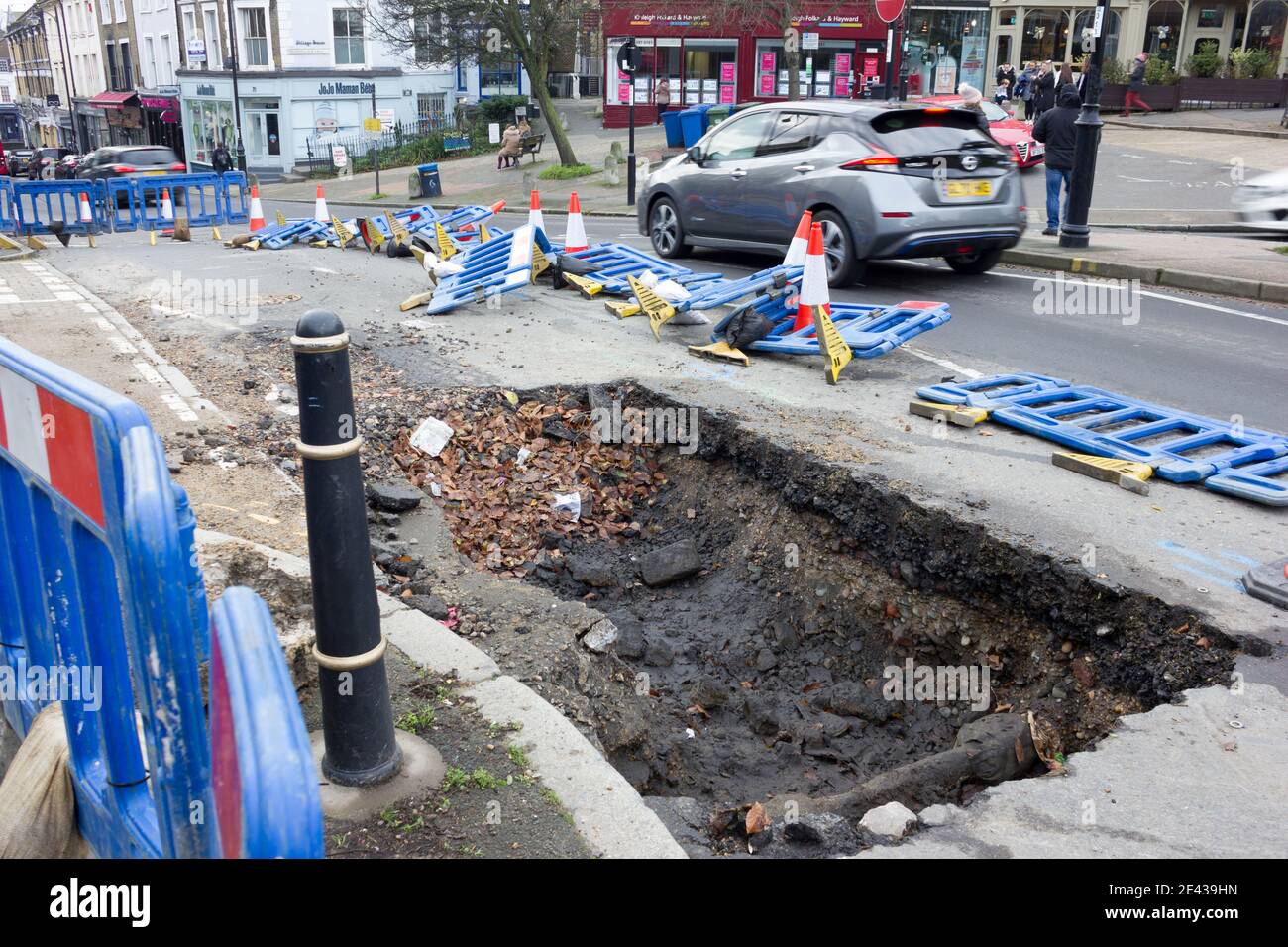 l'éclatement de la conduite d'eau principale a ouvert un grand trou sur la route à l'intérieur blackheath village Londres Angleterre Banque D'Images