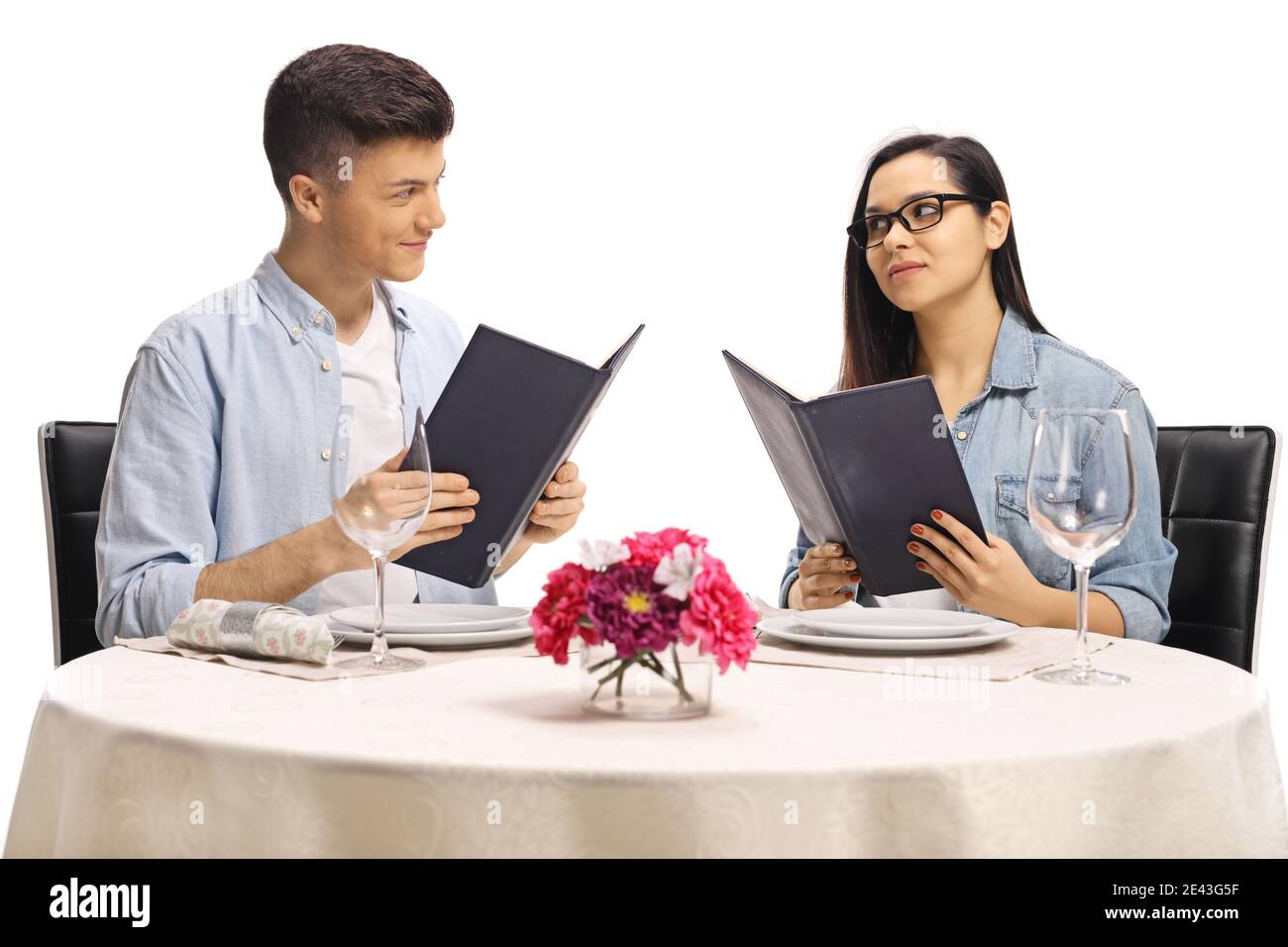 Jeune homme et femme décontracté à une table de restaurant tenue menus et  regarder l'autre isolé sur fond blanc Photo Stock - Alamy