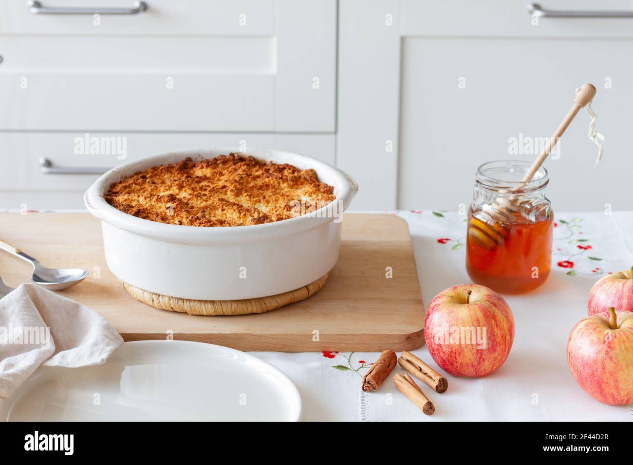 Le miel et les pommes à la cannelle sont placés près de la plaque de cuisson avec délicieux crumble dans la cuisine à la maison Banque D'Images