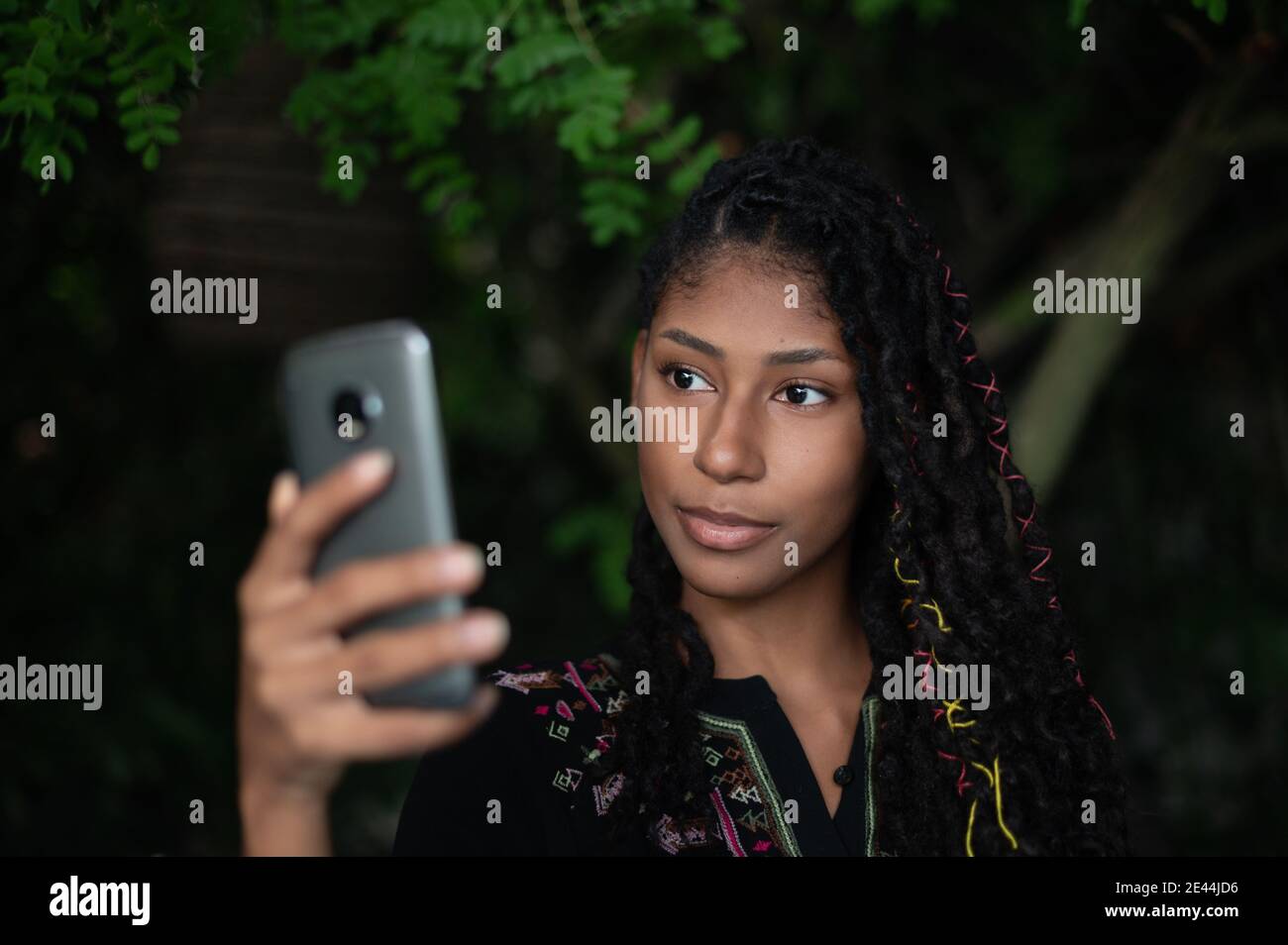 Jeune femme afro latina attrayante prenant un selfie avec un smartphone Banque D'Images