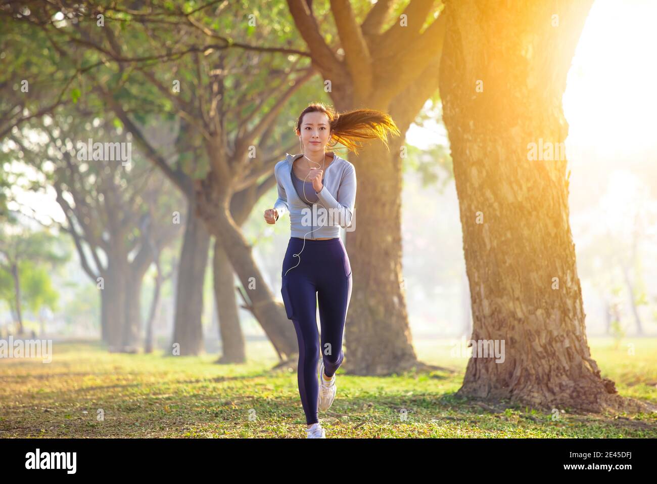 jeune femme qui court dans le parc le matin Banque D'Images