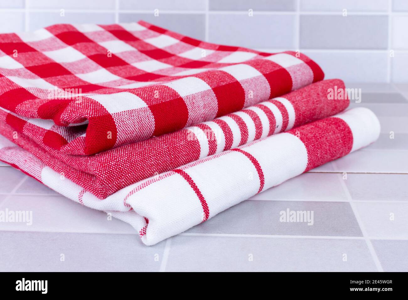 Serviettes de cuisine à carreaux rouges pliées sur une table Photo Stock -  Alamy