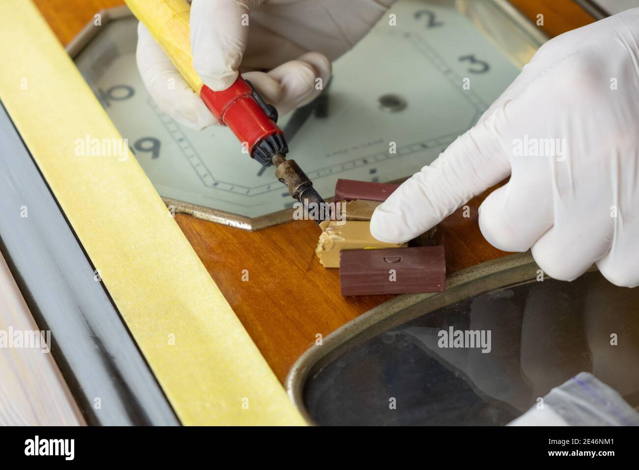 restauration d'anciennes horloges en bois, master scelle la rayure avec de la cire et un fer à souder gros plan Banque D'Images