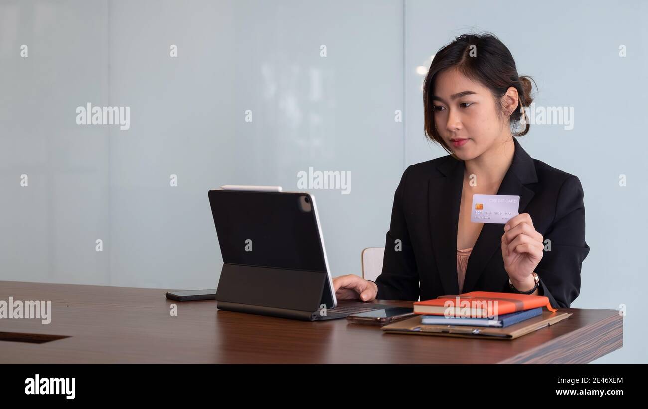 Busiesswoman tenant la carte de crédit et utilisant ordinateur portable pour les achats en ligne, paiement en ligne, e-commerce, banque sur Internet. Banque D'Images