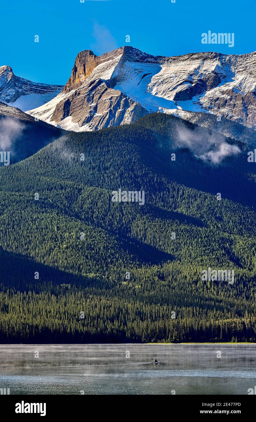 Image verticale d'une scène de montagne rocheuse avec un pêcheur solitaire dans le parc national Jasper, en Alberta, au Canada. Banque D'Images