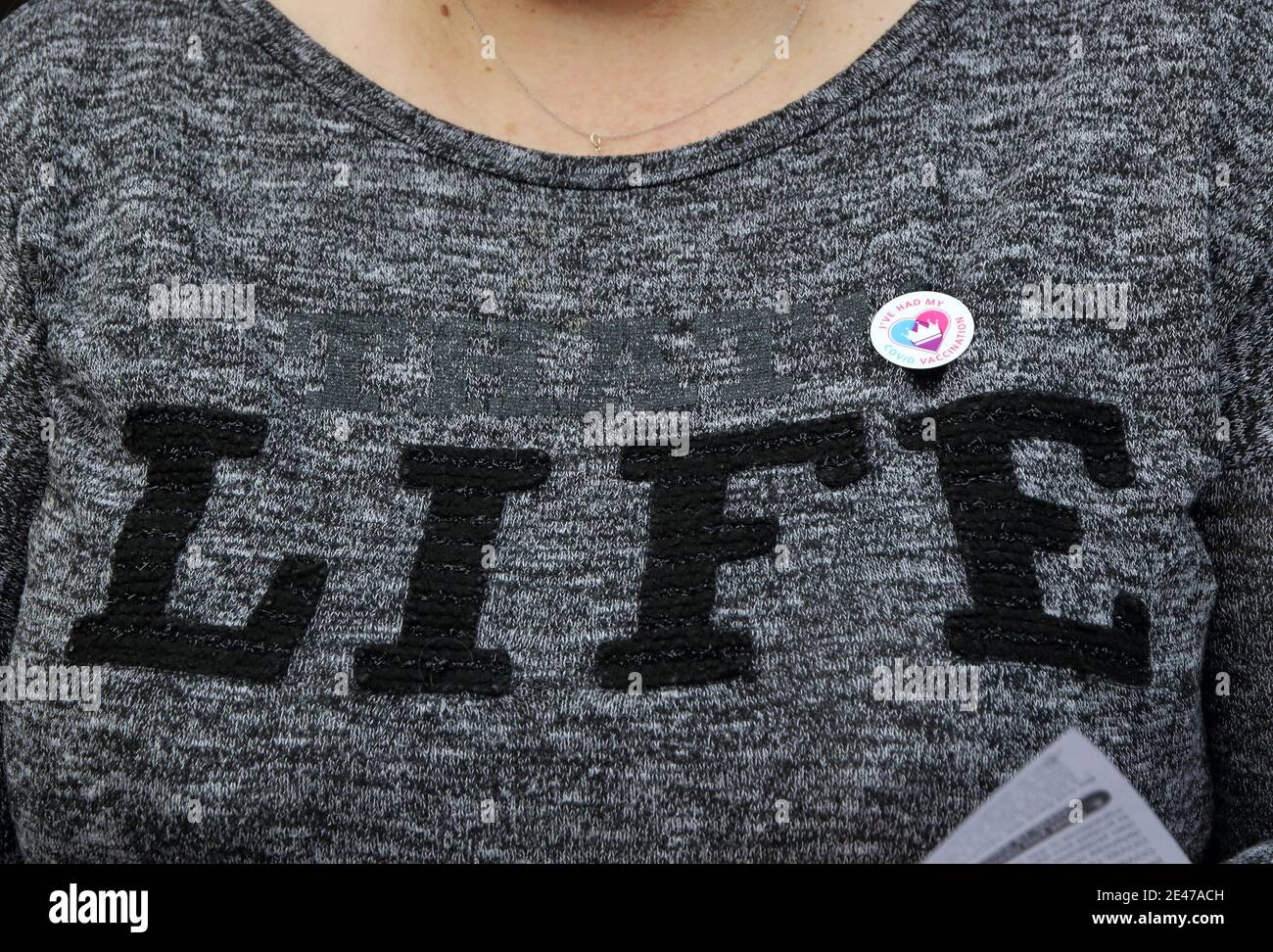 Une femme porte fièrement son autocollant pour dire qu'elle a été vaccinée sur son chandail « Life » au centre de vaccination.UN flux constant de personnes âgées avec rendez-vous pré-réservés au nouveau centre de vaccination Covid-19 au Centre du Bureau olympique, près du stade Wembley de Londres. Il s'agit de l'un des 10 nouveaux centres de vaccination à grande échelle ouverts cette semaine, pour rejoindre les sept déjà en usage dans tout le pays. Jusqu'à présent, 4.9 millions de personnes au Royaume-Uni ont reçu la première dose de vaccin et le gouvernement prévoit que ce nombre passera à 15 millions d'ici le 15 février. Banque D'Images