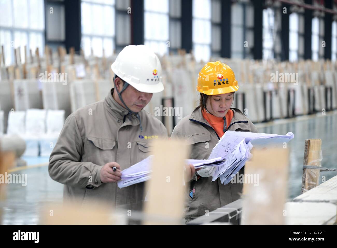 Les travailleurs travaillent des pierres dans une usine de pierre locale, Qianxinan Buyei et la préfecture autonome de Miao, dans la¯province de Guizhou, dans le sud-ouest de la Chine, le 21 janvier 2021. Banque D'Images