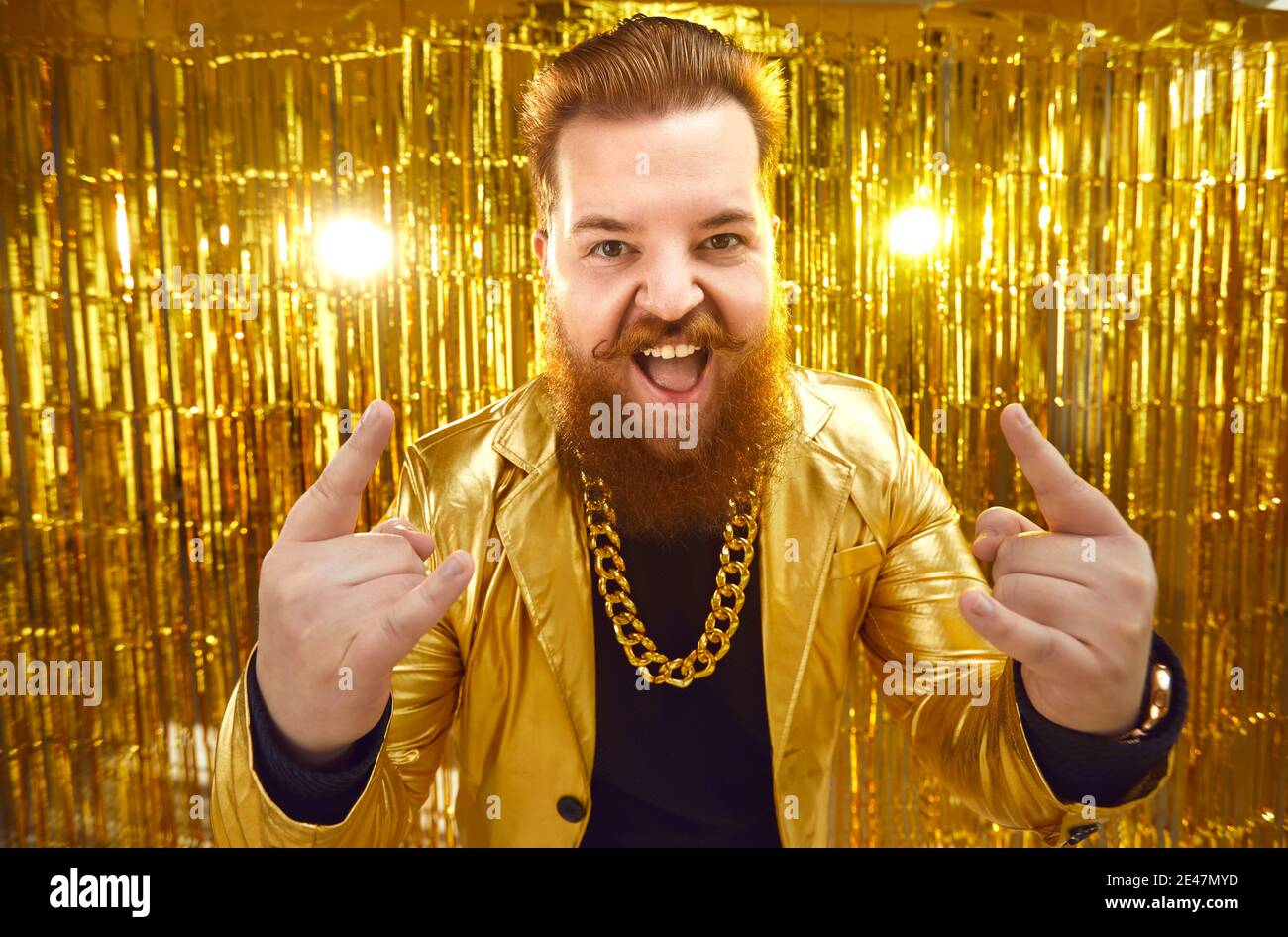 Joyeux excentrique riche jeune homme dans des vêtements extravagants ayant du plaisir lors d'une soirée rock Banque D'Images