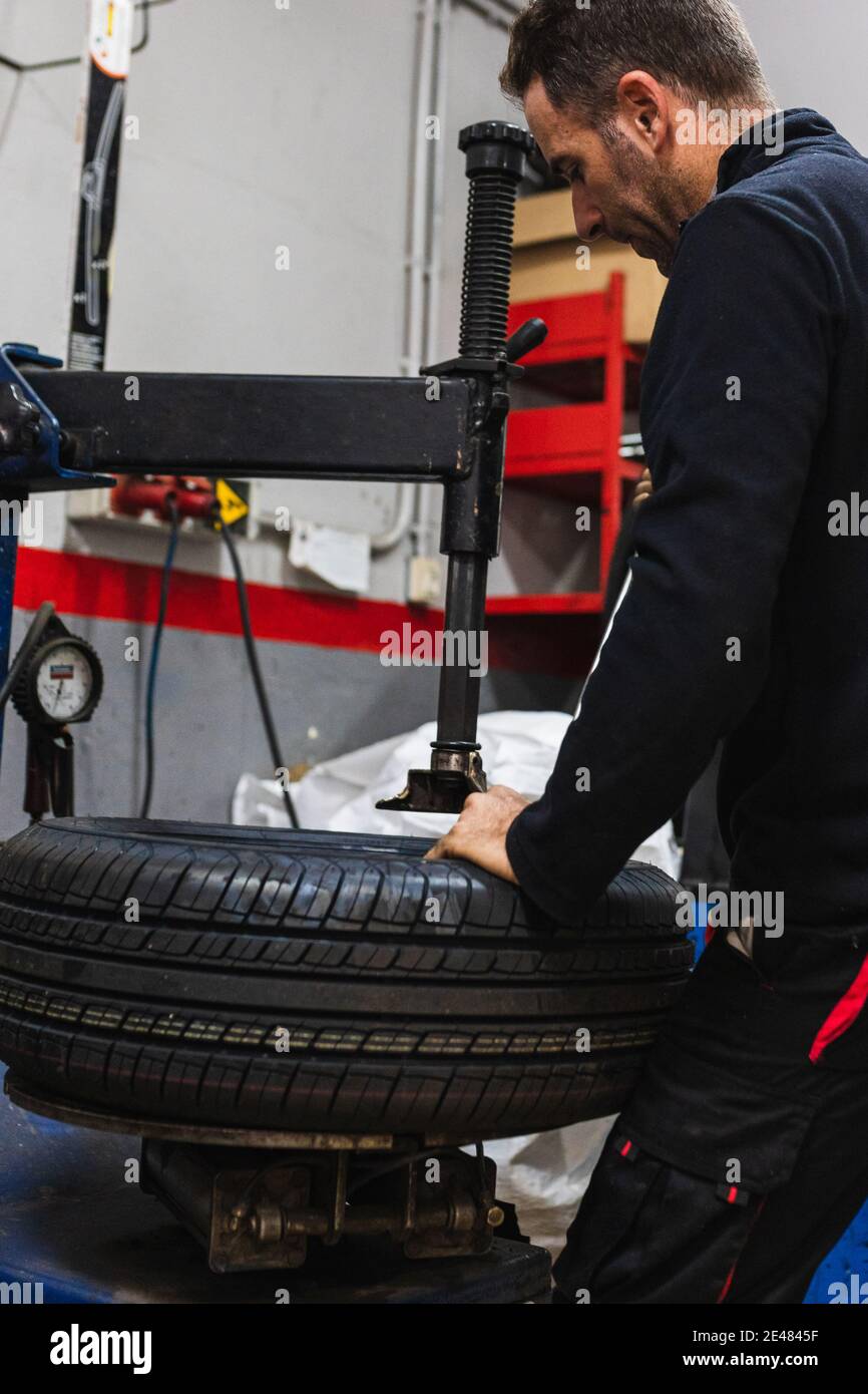 Changement mécanique du caoutchouc d'une roue. Mécanique automobile concept Banque D'Images Changement mécanique du caoutchouc d'une roue. Mécanique automobile concept Banque D'Images