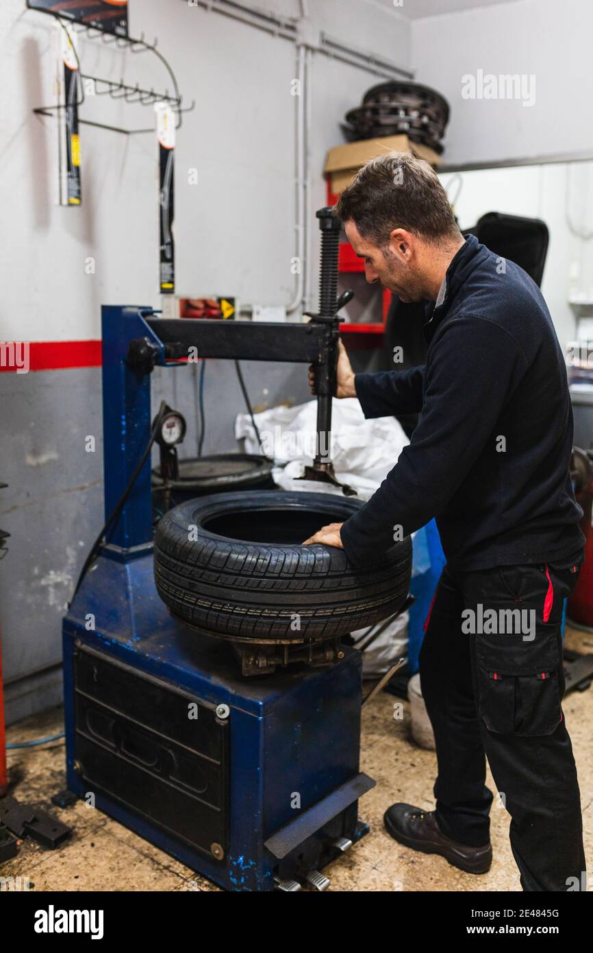 Changement mécanique du caoutchouc d'une roue. Mécanique automobile concept Banque D'Images Changement mécanique du caoutchouc d'une roue. Mécanique automobile concept Banque D'Images