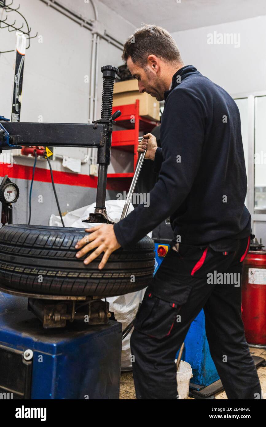 Changement mécanique du caoutchouc d'une roue. Mécanique automobile concept Banque D'Images Changement mécanique du caoutchouc d'une roue. Mécanique automobile concept Banque D'Images