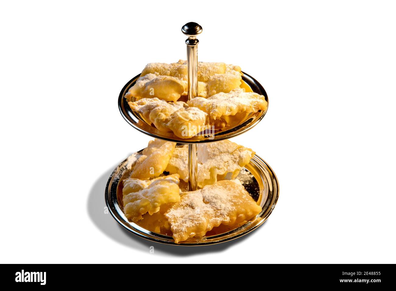 ailes d'ange ou de bugie ou de frappe ou chiacchiere sur plateau à deux niveaux . Tradition culinaire italienne de carnaval. Isolé sur fond blanc Banque D'Images