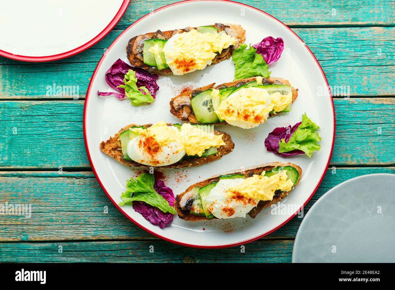 Bruschetta à l'œuf poché, concombre et champignons frits avec sauce hollandaise. Savoureux œufs benedict Banque D'Images