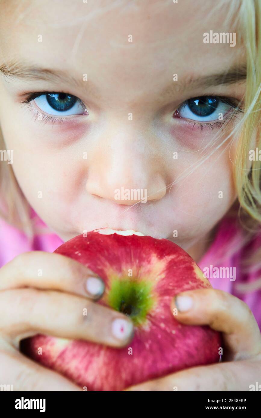 Enfant fille mangeant de la pomme fraîche après avoir putain de l'arbre. Gros plan portrait Banque D'Images