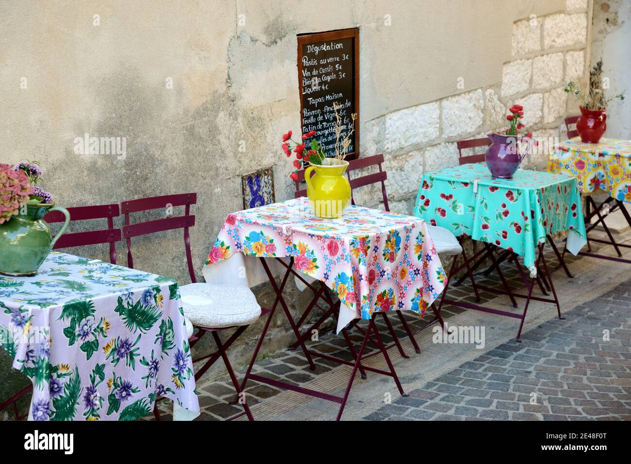 Restaurant extérieur avec tables préparées avec des nappes provençales crues Vases et fleurs à Cassis Provence France Banque D'Images
