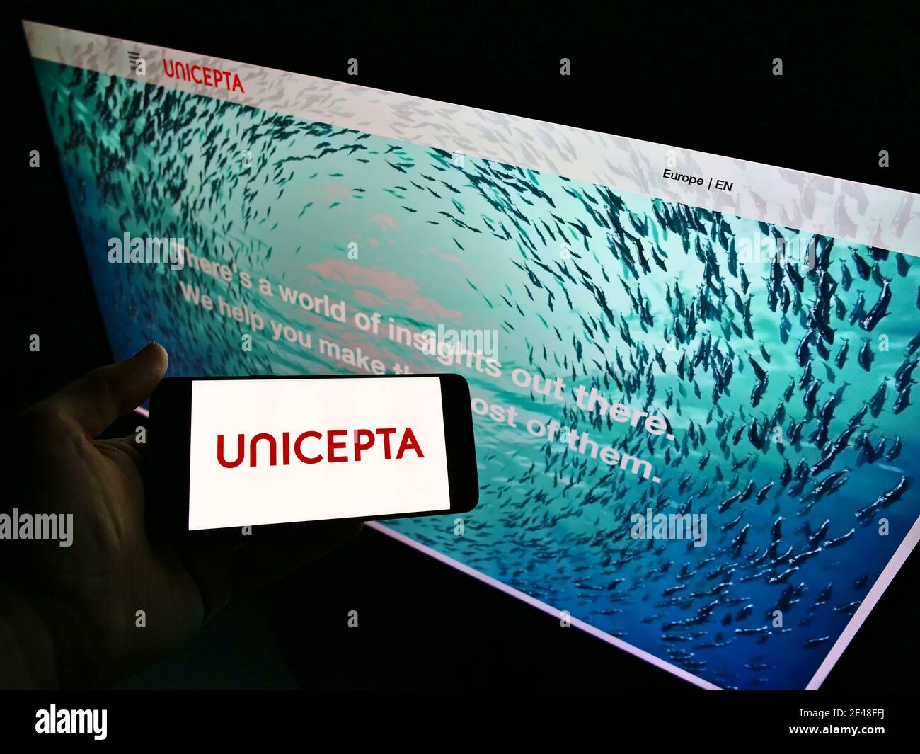 Personne présentant le logo du fournisseur allemand de services de médias et de renseignements sur les données Unicepta GmbH. Mise au point sur l'écran du téléphone mobile. Banque D'Images