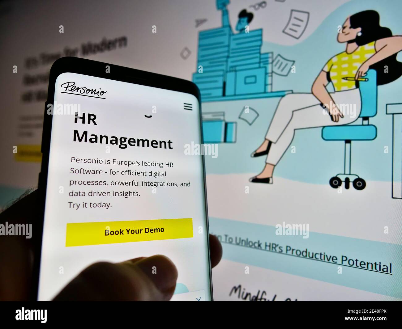 Personne tenant un téléphone avec le site Web et le logo de la société allemande de développement de logiciels RH Personio GmbH à l'écran. Faites la mise au point en haut à gauche de l'écran du téléphone portable. Banque D'Images