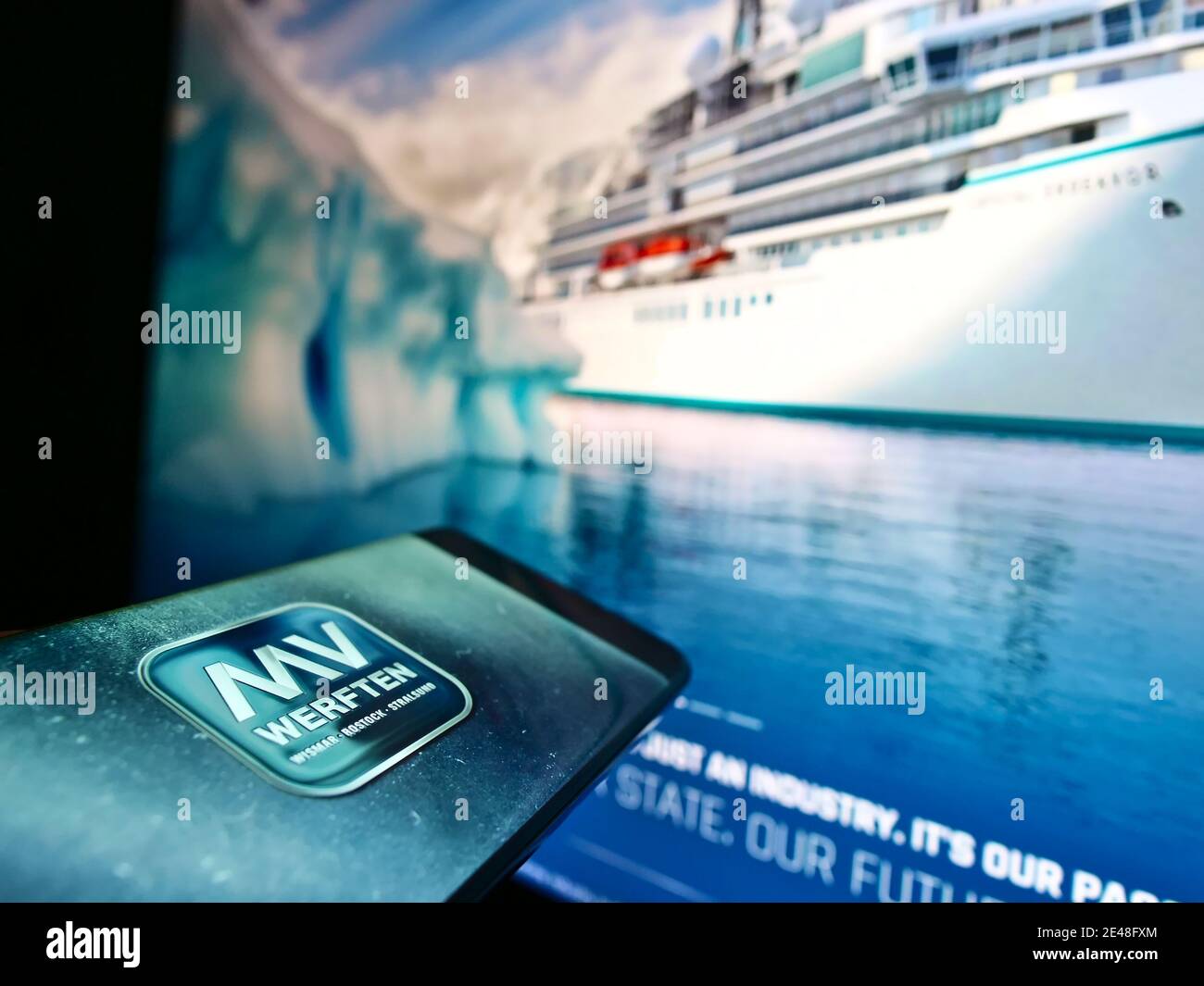 Téléphone portable avec logo de la société allemande de construction navale MV Werften devant le site Web d'affaires avec navire. Mise au point au centre de l'écran du téléphone. Banque D'Images