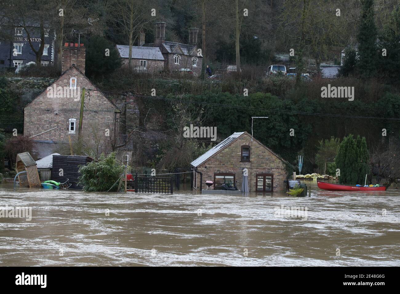 Une maison appartenant à Vic Haddock (à gauche) et à la Boathouse d'où il exploite son entreprise de location de canoës (à droite) sont entourées par les eaux de crue de la rivière Severn à Ironbridge, Shropshire, après que Storm Christoph ait causé des inondations à travers le Royaume-Uni. Date de la photo: Vendredi 22 janvier 2021. Banque D'Images