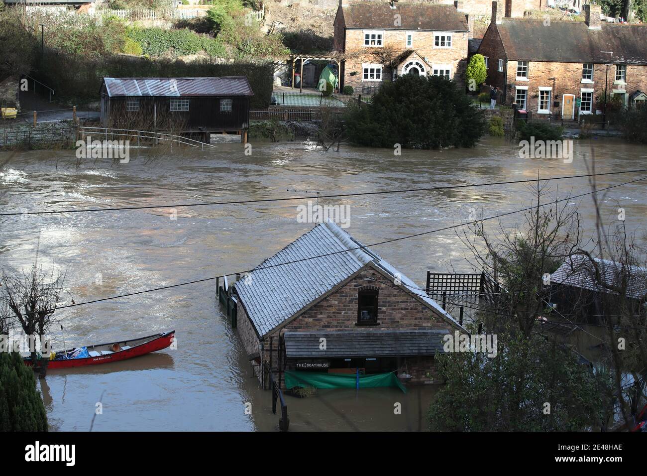 Le Boathouse (à l'avant) d'où Vic Haddock exploite sa location de canoës et son commerce de chambres d'hôtes (à droite) sont entourés par les eaux de crue de la rivière Severn à Ironbridge, Shropshire, après que Storm Christoph ait causé des inondations à travers le Royaume-Uni. Date de la photo: Vendredi 22 janvier 2021. Banque D'Images