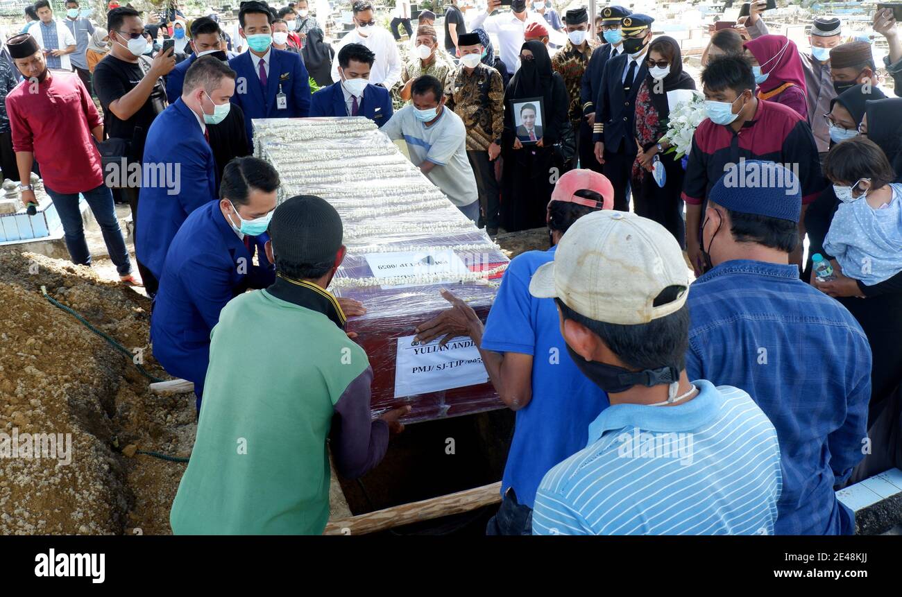 Bangka Belitung, Indonésie. 22 janvier 2021. Les pallbearers abaissent un cercueil portant les restes de Yulian Andhika, un steward qui a péri à bord de la Sriwijaya Air SJ 182 qui s'est écrasée dans la mer de Java quelques minutes après le décollage de Jakarta le 9 janvier, lors de funérailles au cimetière public Srimenanti sur l'île indonésienne de Bangka Belitung le 22 janvier. 2021. (Photo par Hairul Ashter/INA photo Agency/Sipa USA) crédit: SIPA USA/Alay Live News Banque D'Images