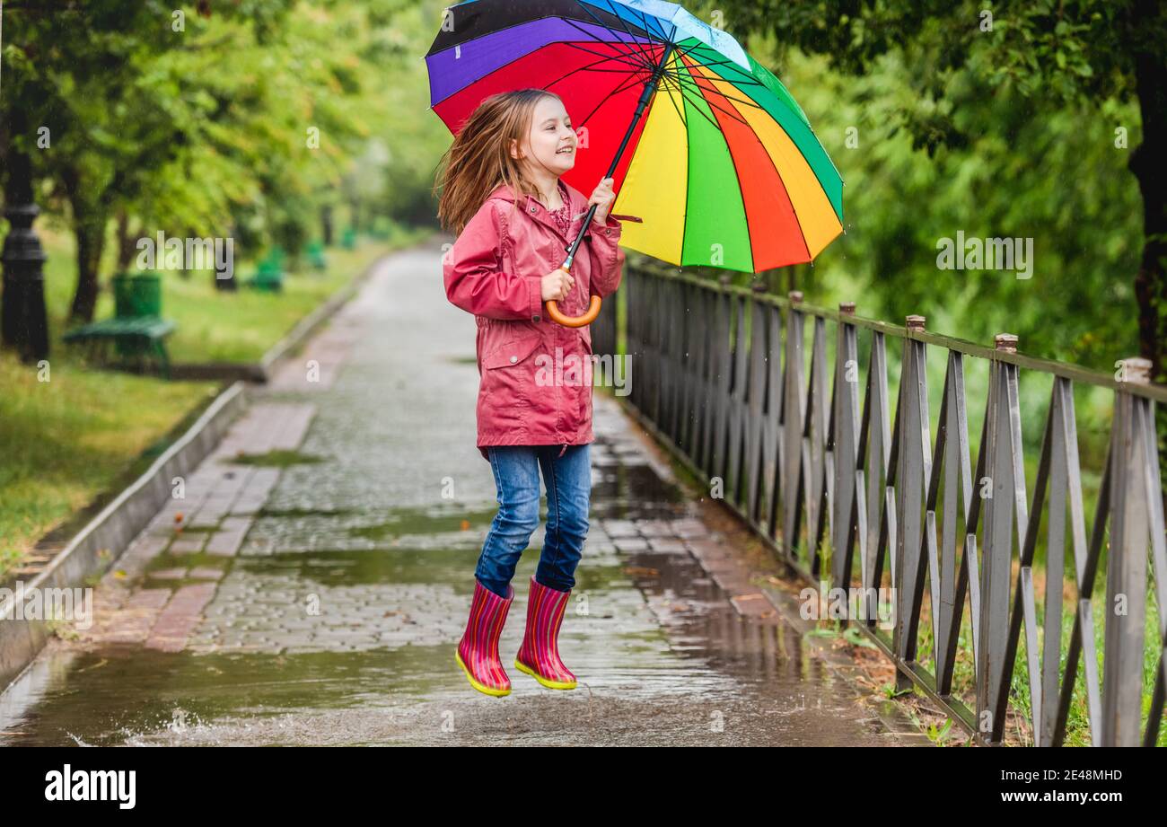 Little girl jumping in puddle Banque D'Images