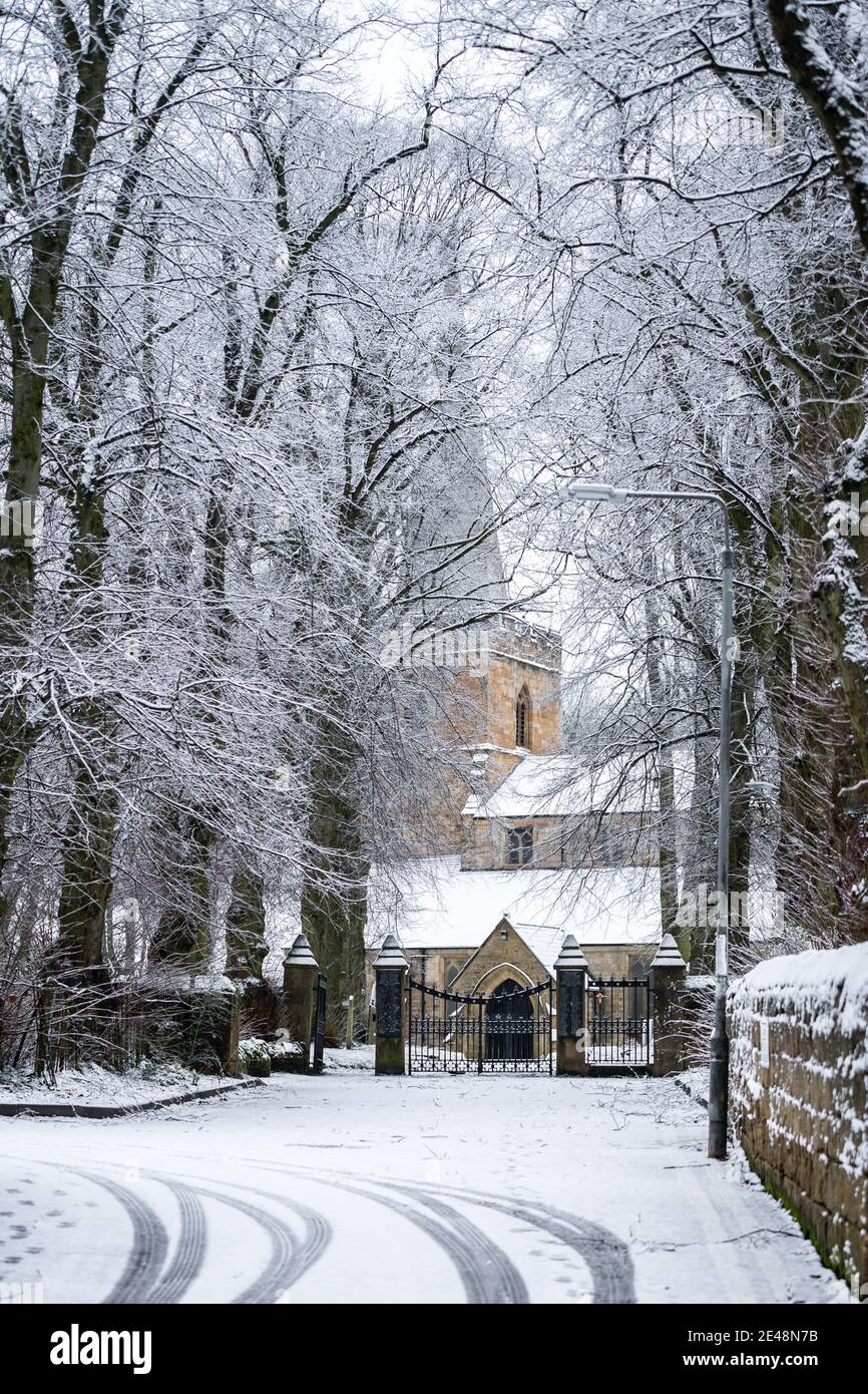 Hiver une belle scène d'église de village avec chute de neige profonde sur le toit et l'allée chute de neige installée avec des arbres en pierre Mur dans la ville de Sutton à Ashfield Banque D'Images