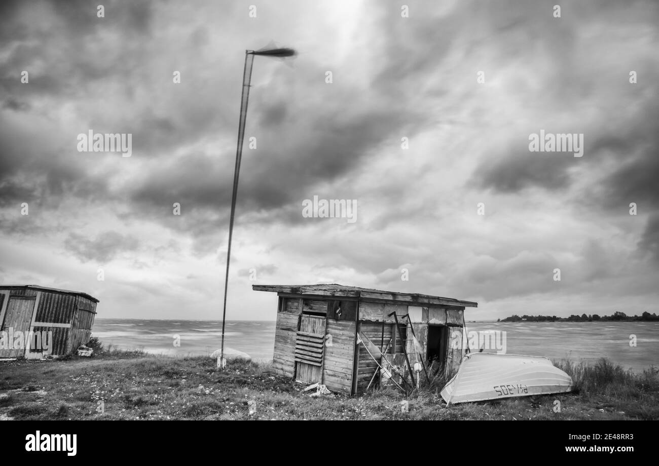 TAHKURANNA, ESTONIE - 17 septembre 2020 : ancien port de pêche local avec cabanes et bateau avec baie de mer orageux et fond ciel nuageux Banque D'Images