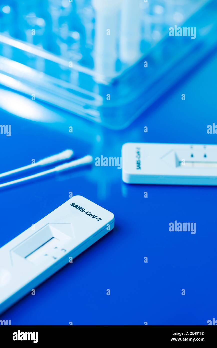 certains kits de test rapide de l'antigène covid-19, avec les dispositifs de test de diagnostic et certains écouvillons nasopharyngés, sur une surface bleue Banque D'Images