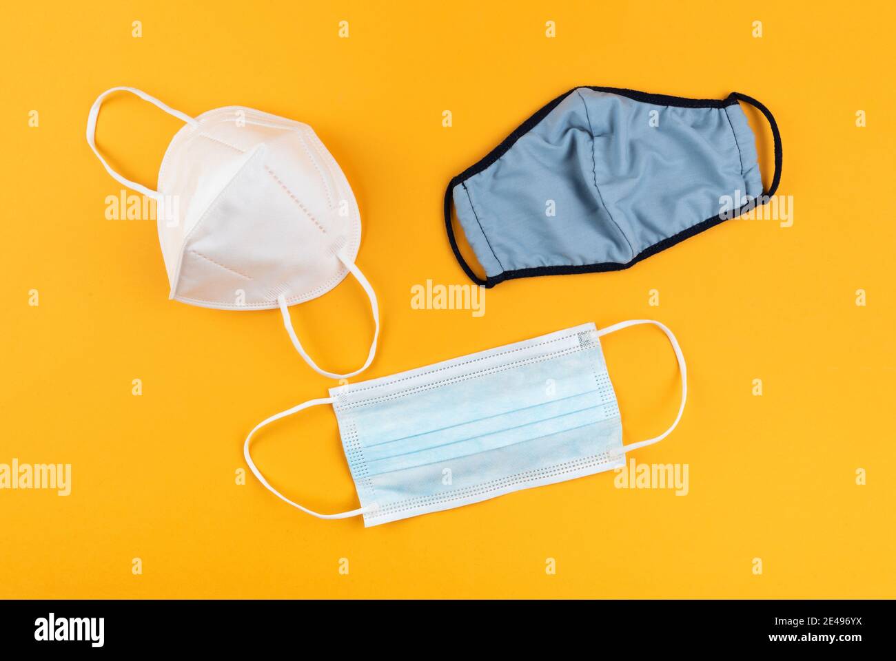 différents types de masques protecteurs ou de revêtements de visage sur fond orange vif, concept de protection du coronavirus covid-19 Banque D'Images