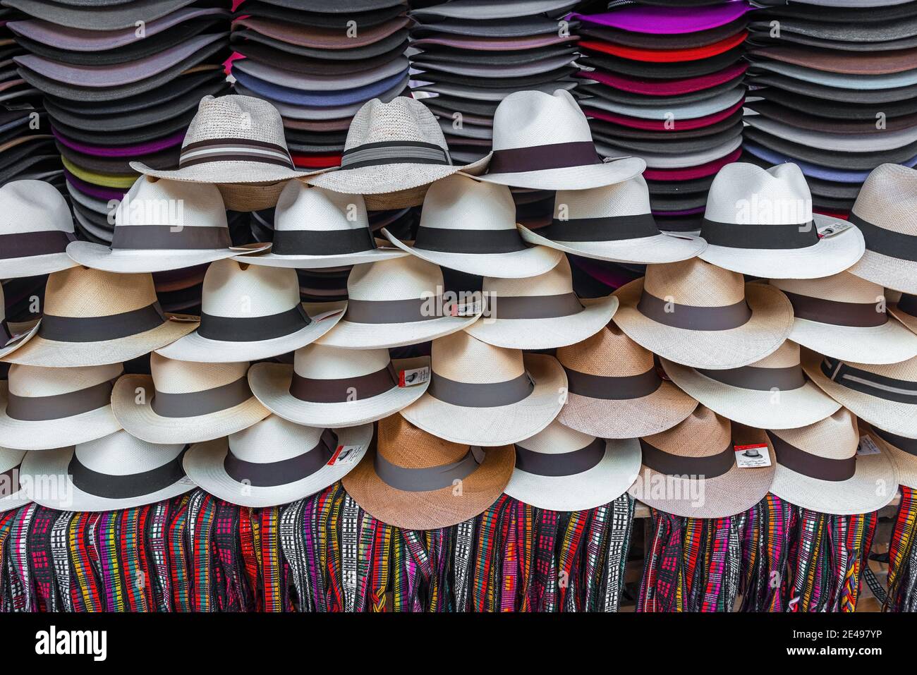 Stand avec des chapeaux Panama et des bracelets colorés à vendre sur le marché de l'art et de l'artisanat Otavalo, Equateur. Banque D'Images