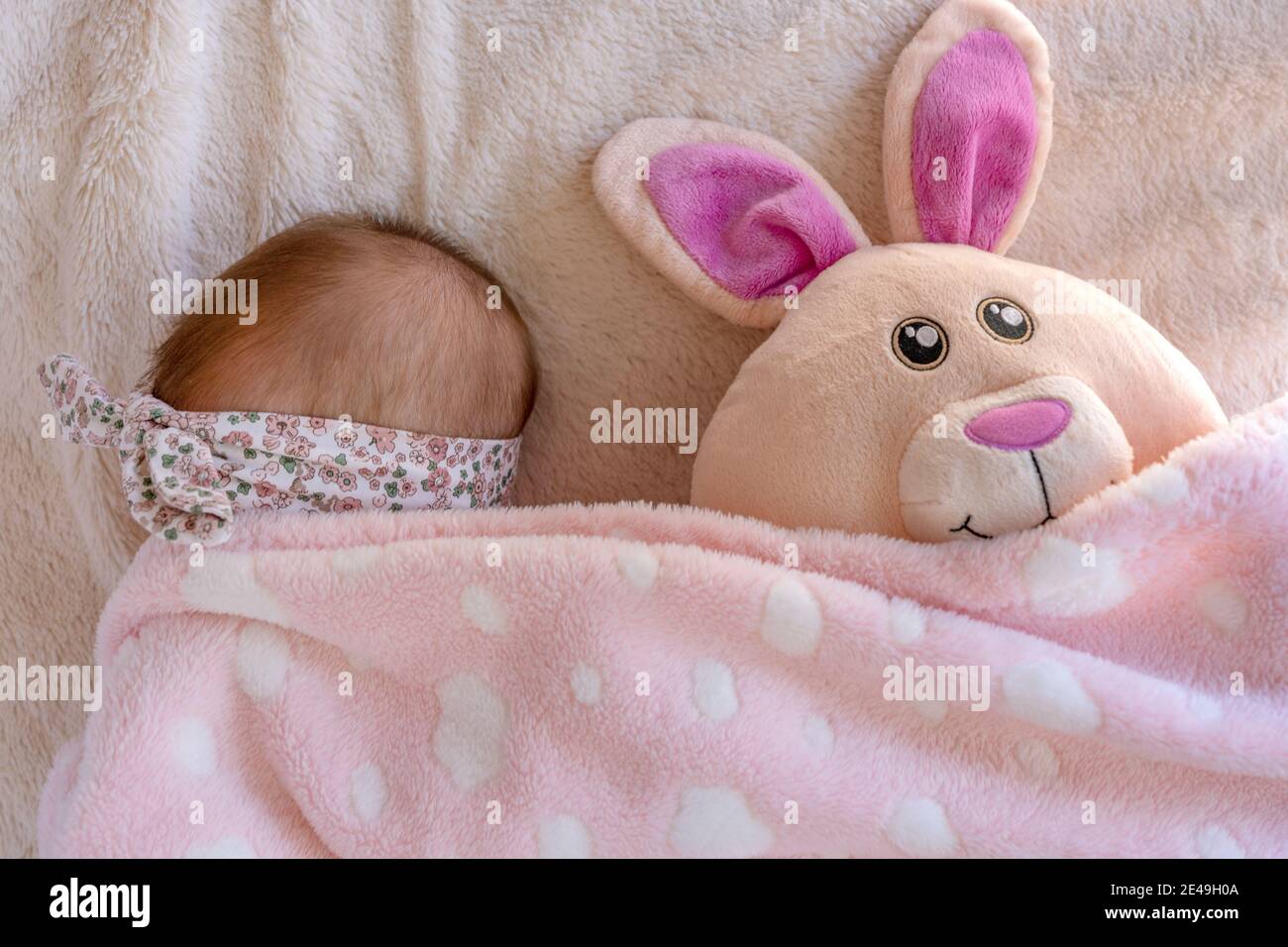 petite fille de bébé se cachant sous sa couverture avec ses pâques peluche lapin peluche peluche câleux Banque D'Images