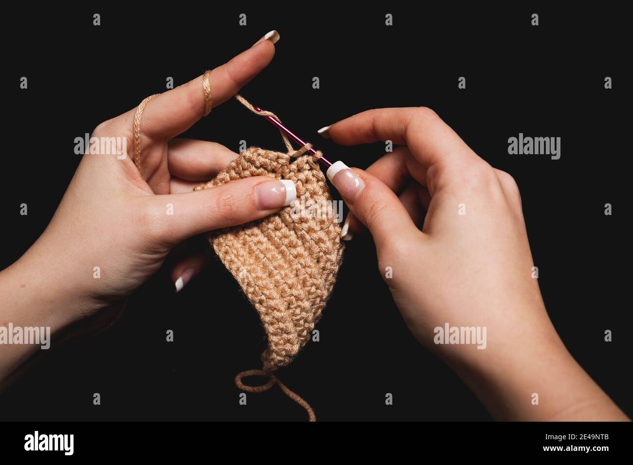 Gros plan des mains de femmes tricotage de la laine de coton avec aiguille, Banque D'Images