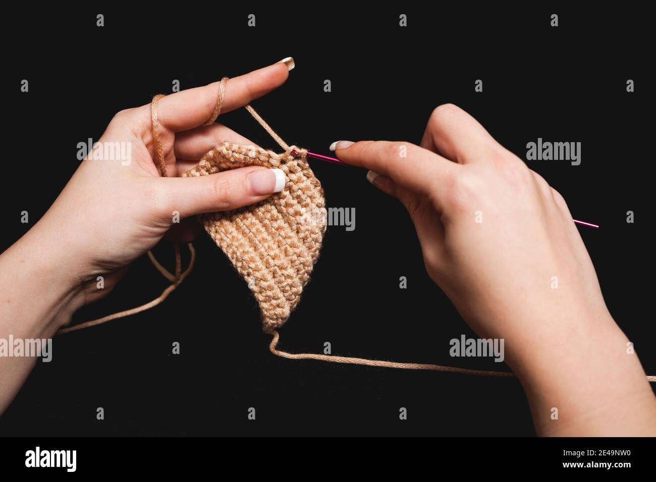 Gros plan des mains de femmes tricotage de la laine de coton avec aiguille, Banque D'Images