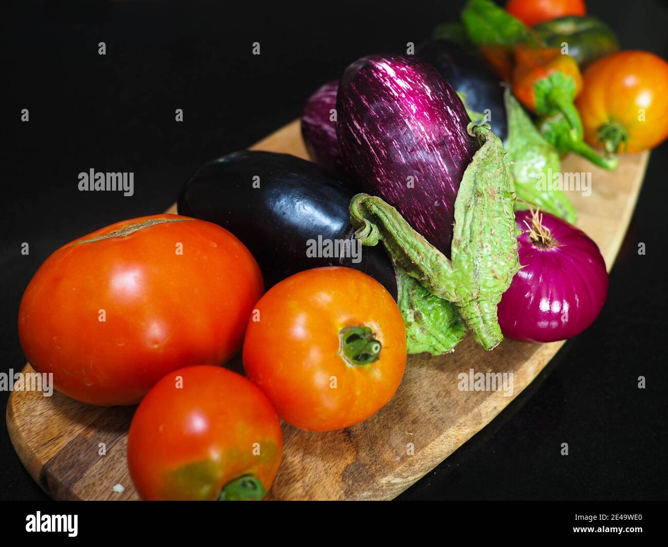 Aubergines fraîches, tomates, poivrons, oignons récoltés dans le jardin Banque D'Images