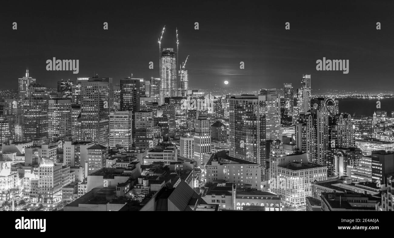 La vue panoramique sur la lune en noir et blanc s'élève derrière les tours du quartier financier du centre-ville de San Francisco, en Californie. Banque D'Images