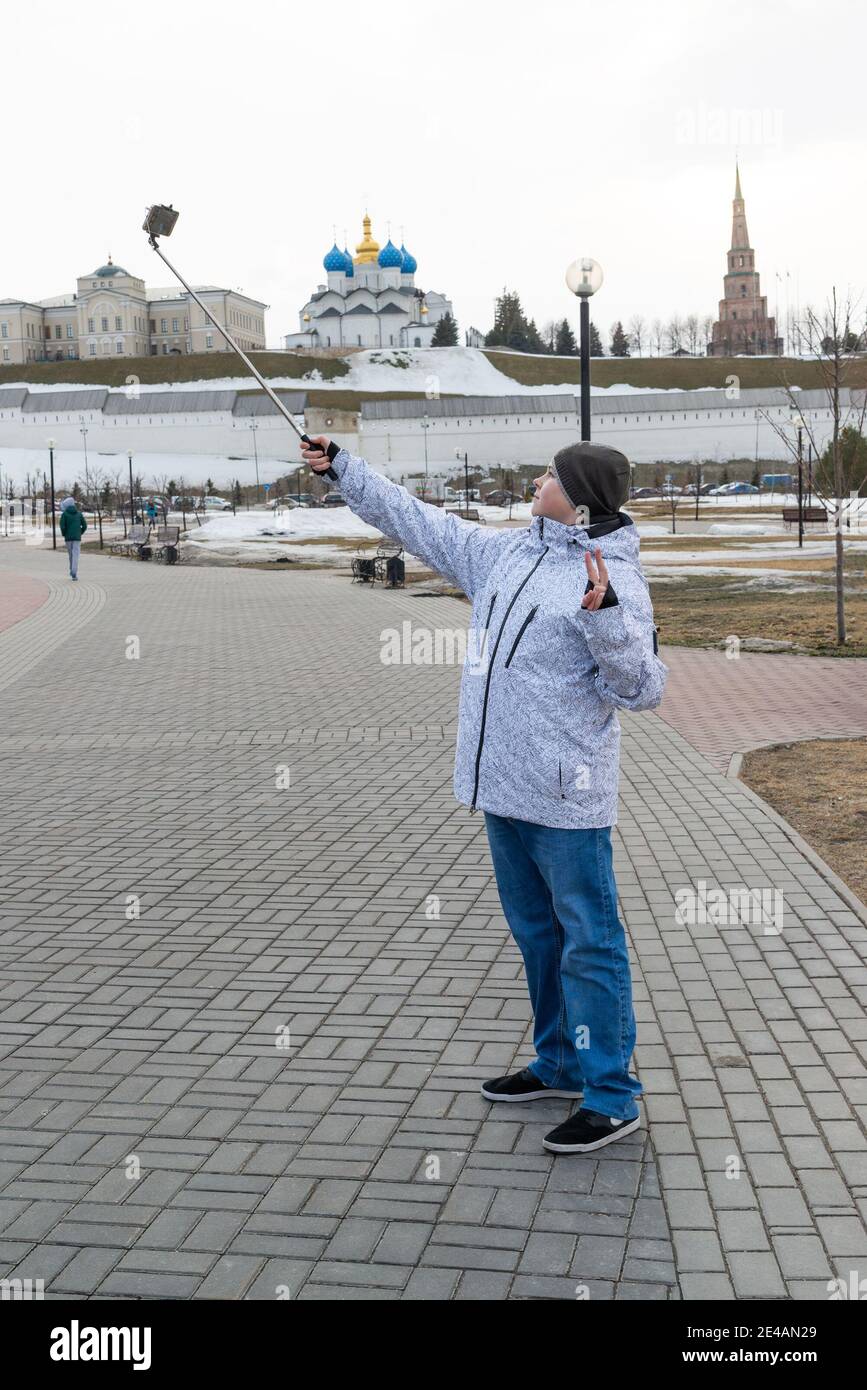Garçon fait le selfie au téléphone avec l'auto-bâton sur fond de Kremlin de Kazan, la Russie Banque D'Images