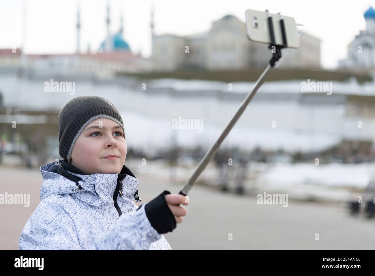 Garçon fait le selfie au téléphone avec l'auto-bâton sur fond de Kremlin de Kazan, la Russie Banque D'Images