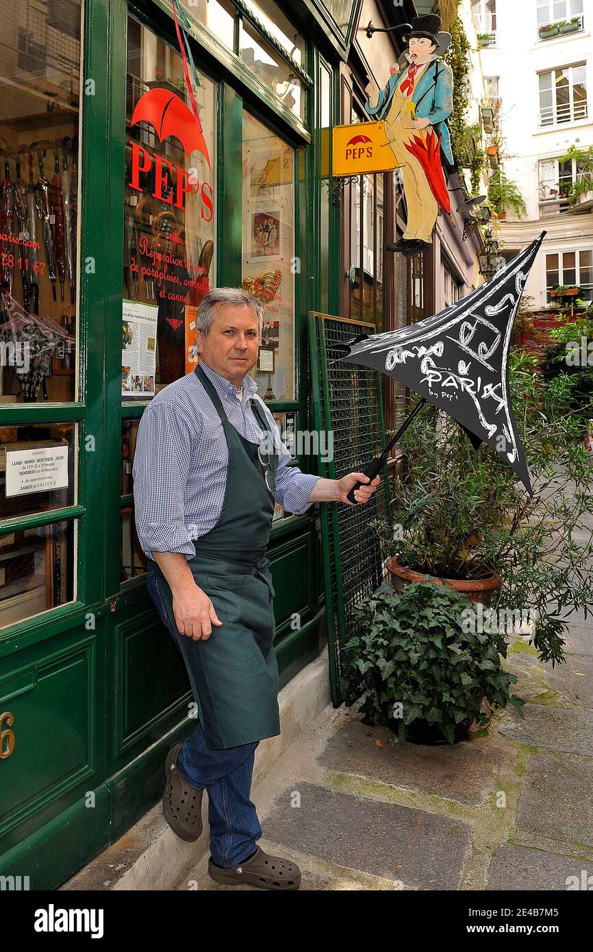 Thierry Millet, le dernier réparateur de parapluie français, pose avec sa  dernière invention, un parapluie 'Tour Eiffel' devant son atelier 'PEP'S,  dans le passage de l'Ancre, troisième arrondissement de Paris, France en