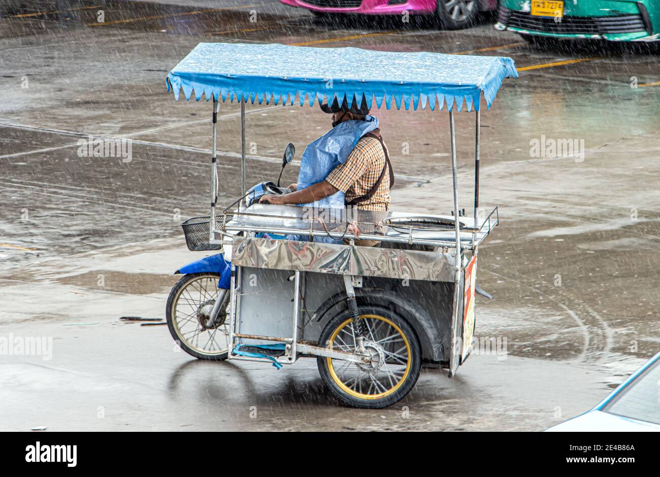 SAMUT PRAKAN, THAÏLANDE, JUILLET 21 2020, le vendeur conduit une moto à trois roues sous la pluie Banque D'Images