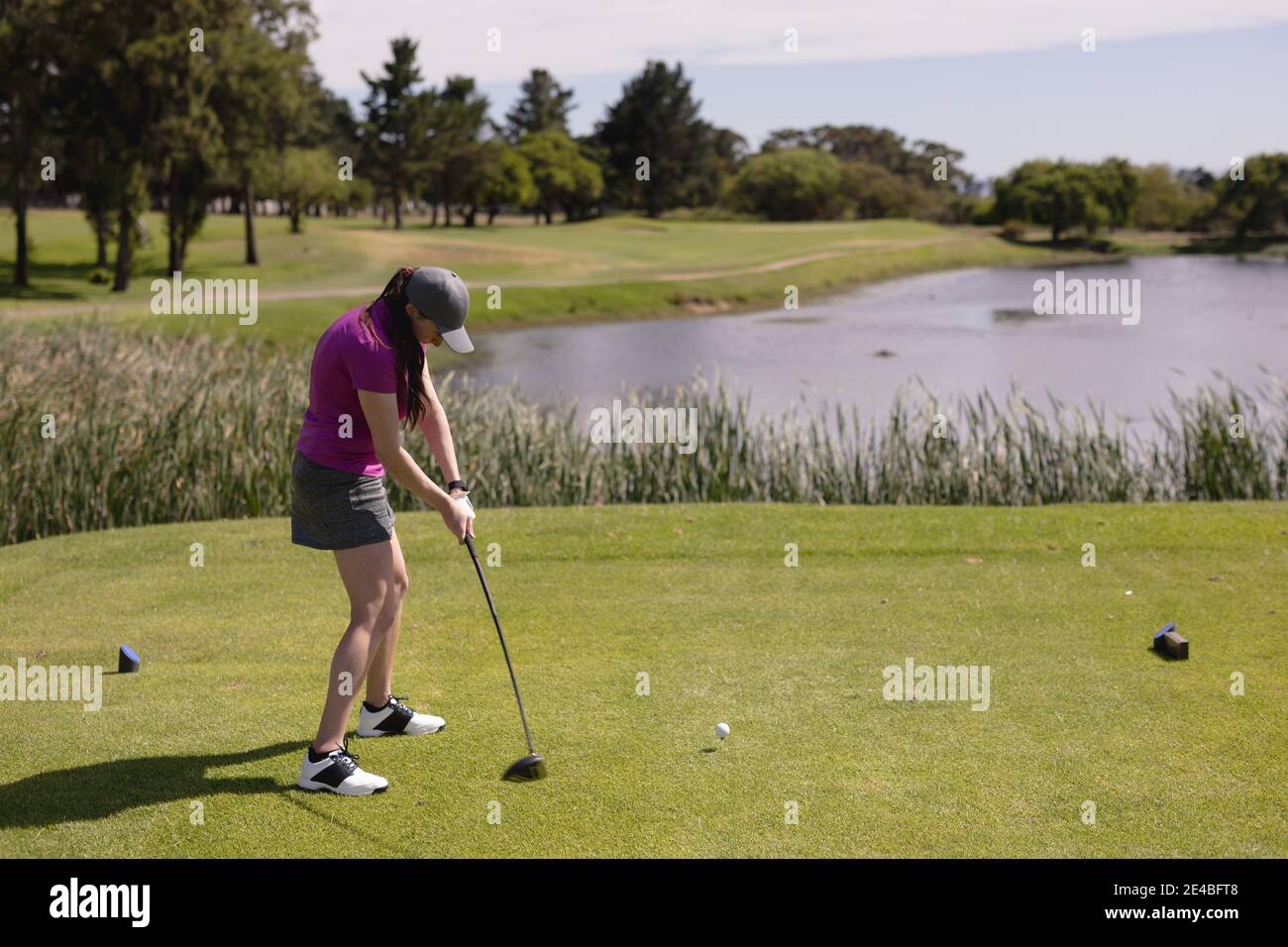 Femme caucasienne jouant au golf swing club et prenant un coup de feu Banque D'Images