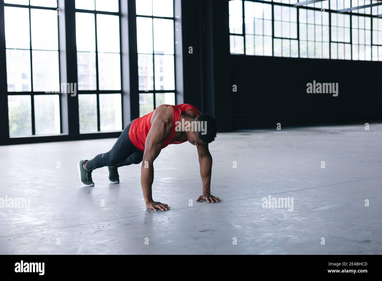 Homme afro-américain portant des vêtements de sport faisant des retouches bâtiment urbain vide Banque D'Images