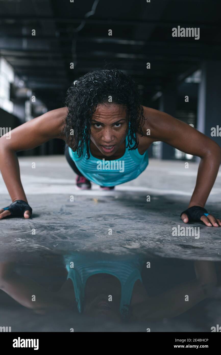 Femme afro-américaine portant des vêtements de sport faisant des pressions bâtiment urbain vide Banque D'Images