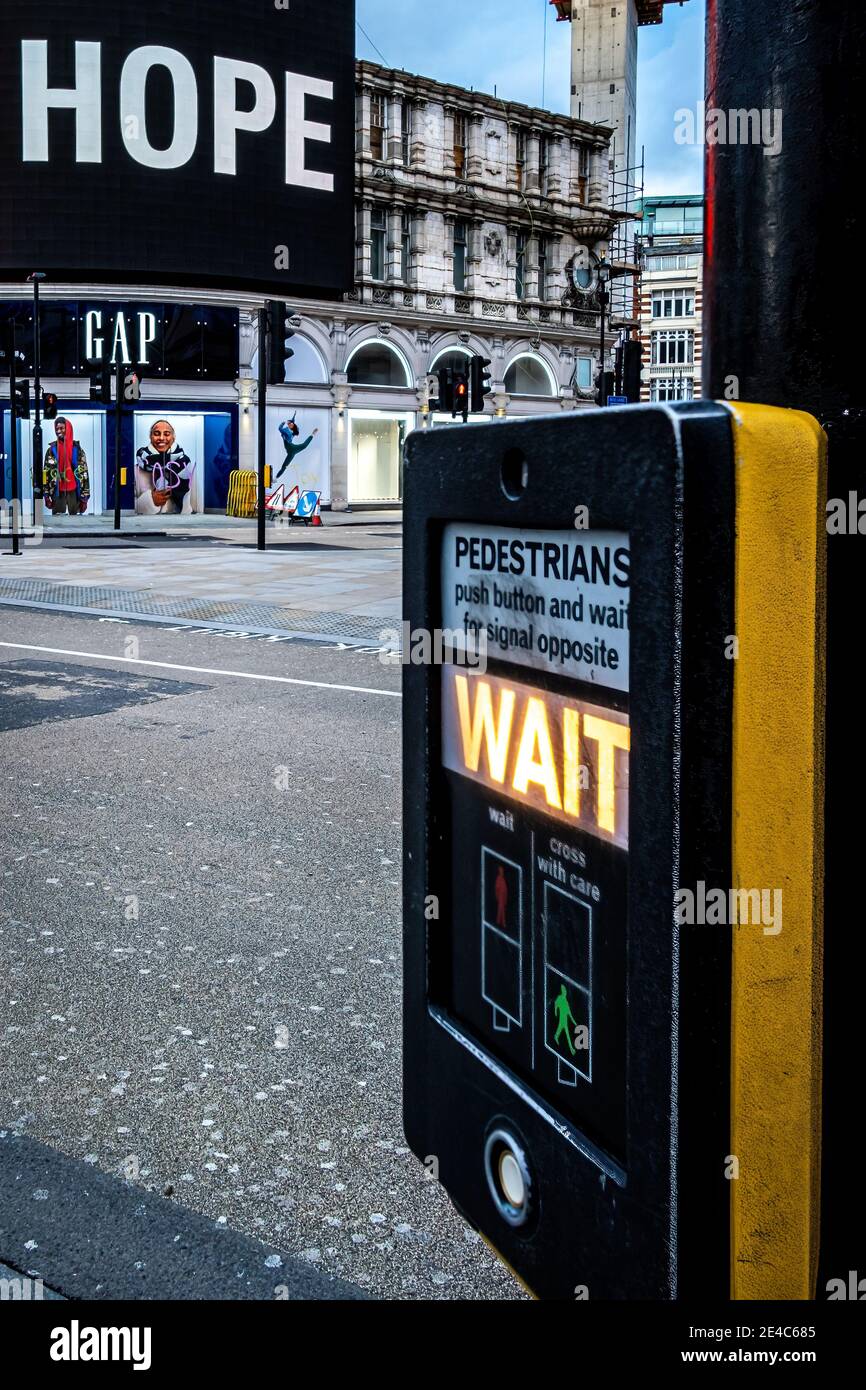 Angleterre, Londres. 22 janvier 2021. Le panneau publicitaire et le panneau d'attente de passage pour piétons se combinent pour résumer la situation actuelle sous le confinement 3. Banque D'Images