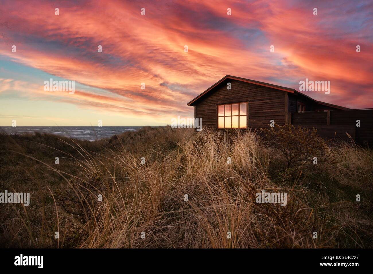Maison dans les dunes au coucher du soleil sur une plage près de Hirtshals. Banque D'Images