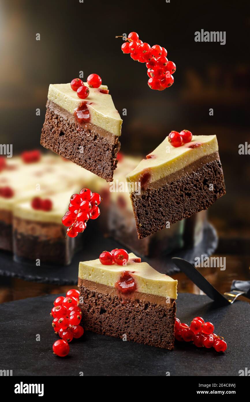 Concept de confiserie avec des gâteaux volants avec cassis rouge, mouss au chocolat et crème au fromage sur le dessus. Dessert sain frais et cuit à la levité. Banque D'Images