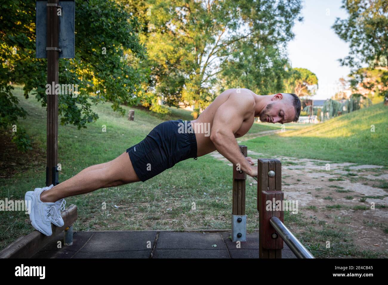 European Fitness pour hommes, des push-ups à l'extérieur sur un bar dans un parc. Banque D'Images