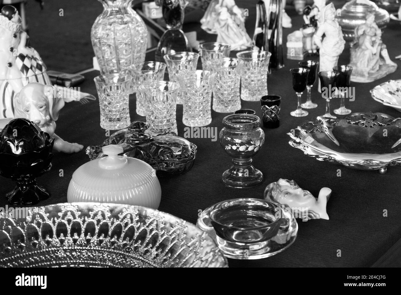 Coupes, verres, assiettes, porcelaine, poterie et autres objets en cristal exposés sur un marché aux puces [version noir et blanc] Banque D'Images