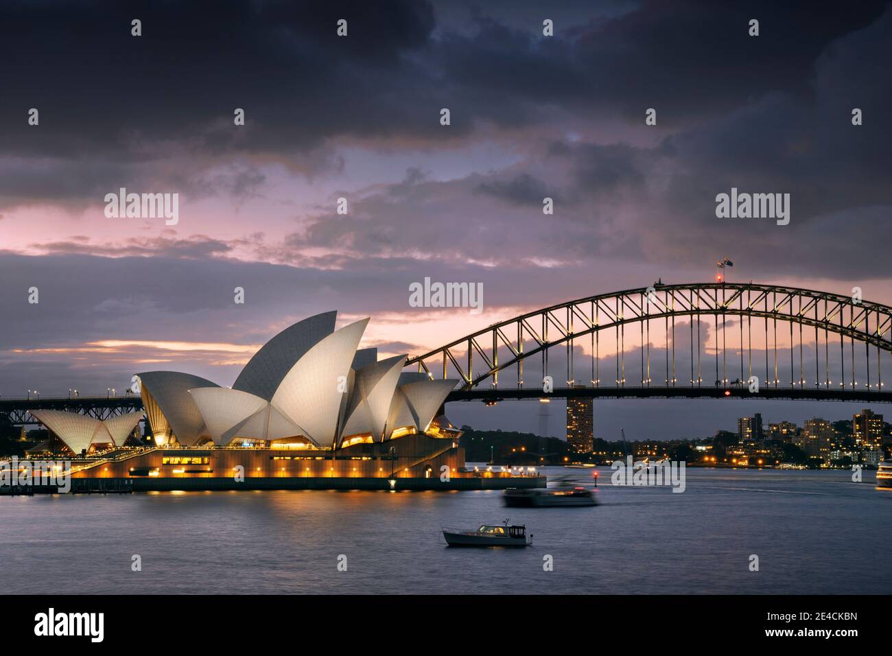 L'Opéra de Sydney illuminé avec Harbour Bridge au coucher du soleil Banque D'Images