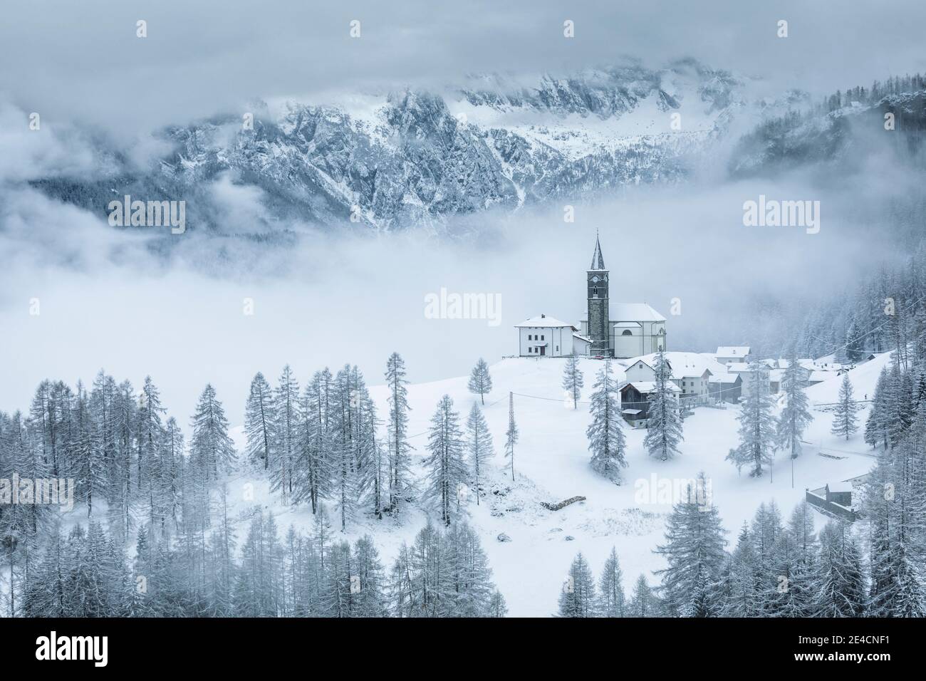 Italie, Vénétie, province de Belluno, Rocca Pietore, Agordino, le village de Laste en hiver avec l'église de San Gottardo sur la colline, Dolomites Banque D'Images